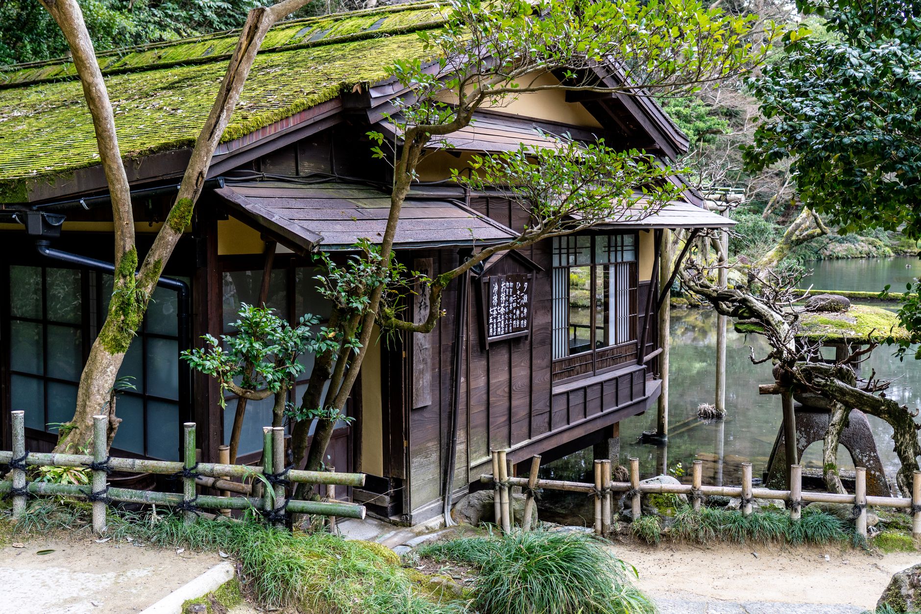 Traditional Japanese tea room overlooking rain on stone lanterns