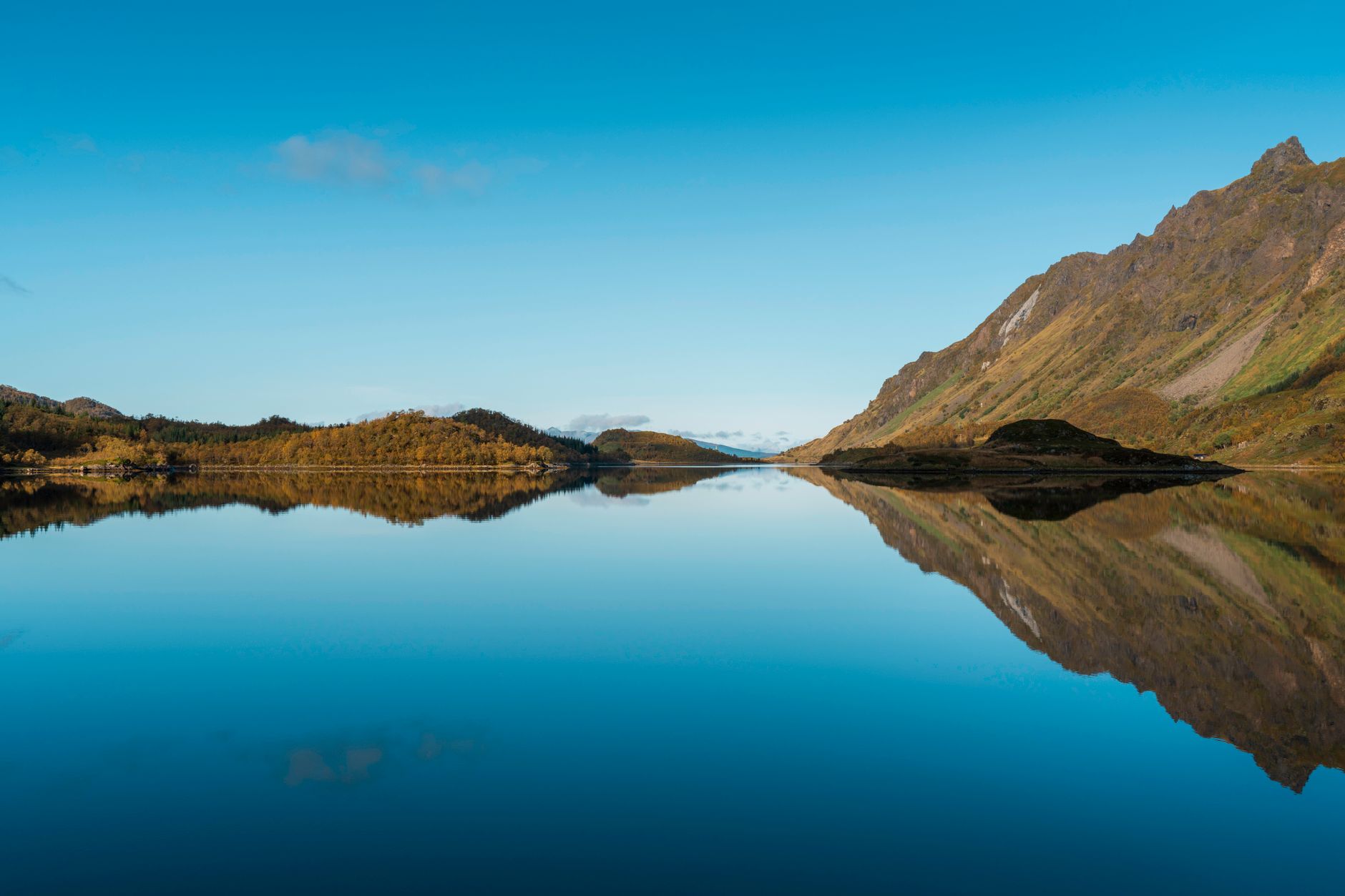 Tranquil coastal fjord reflecting majestic Nordic mountains